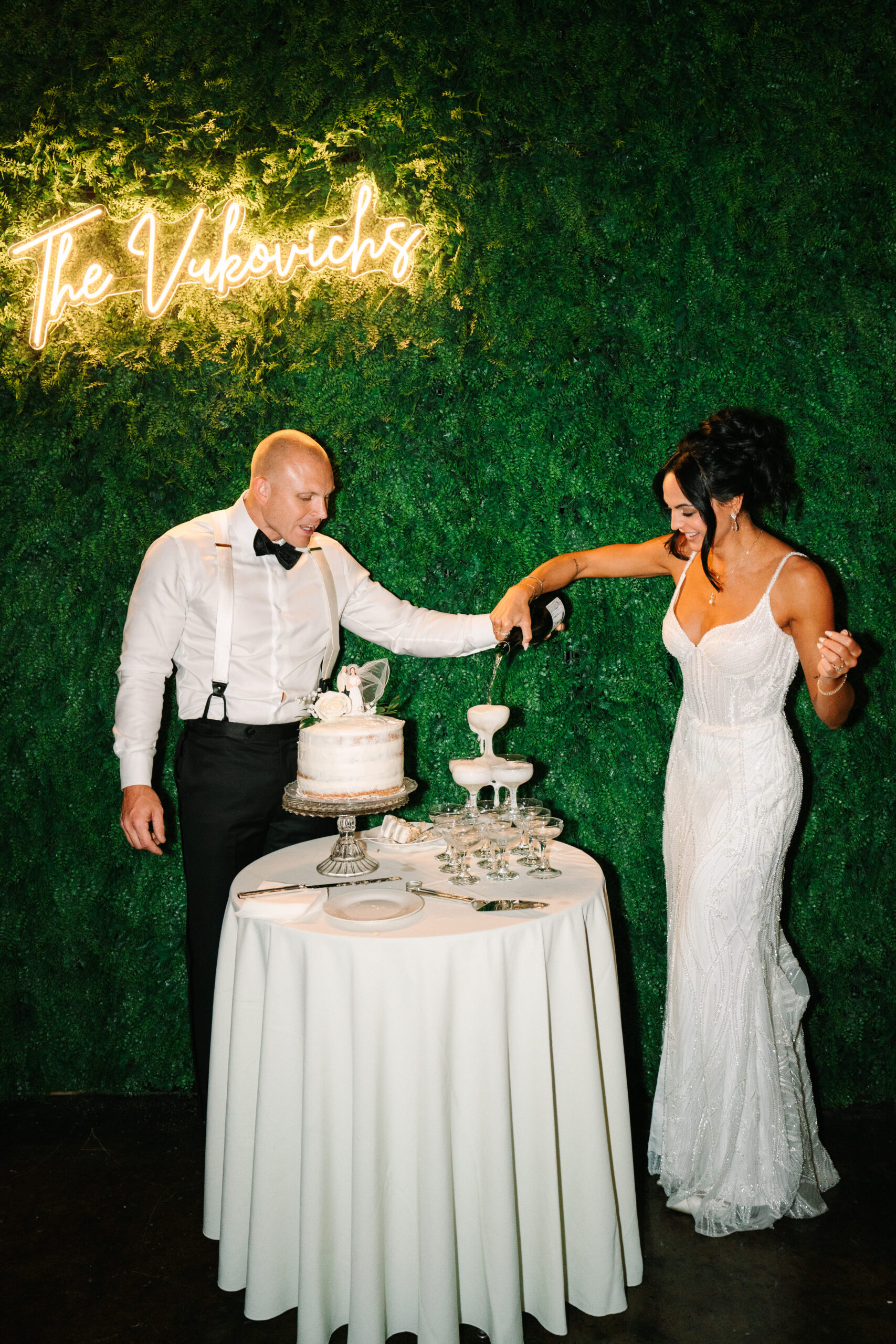 wedding reception, Wedding at the Evansville Museum of Arts, Indiana wedding, bride and groom, champagne tower, neon sign, wedding greenery wall